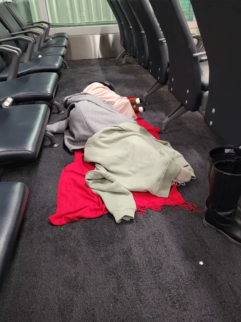 child sleeping on floor at JFK airport