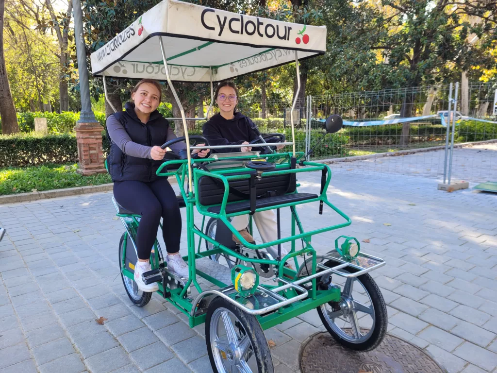 girls on 4 wheel bike in Maria Luisa Park in Seville