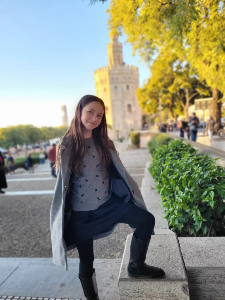 Girl posing in front of Torre del Oro in Seville