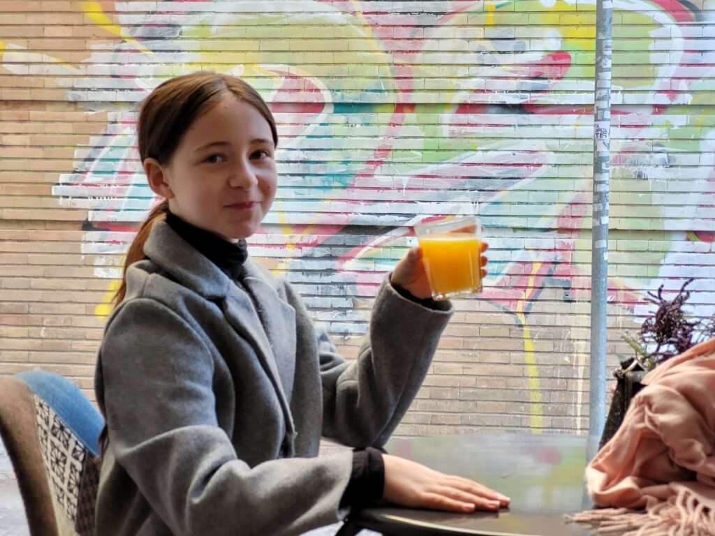 Sophia drinking orange juice at Boca Floja in Seville