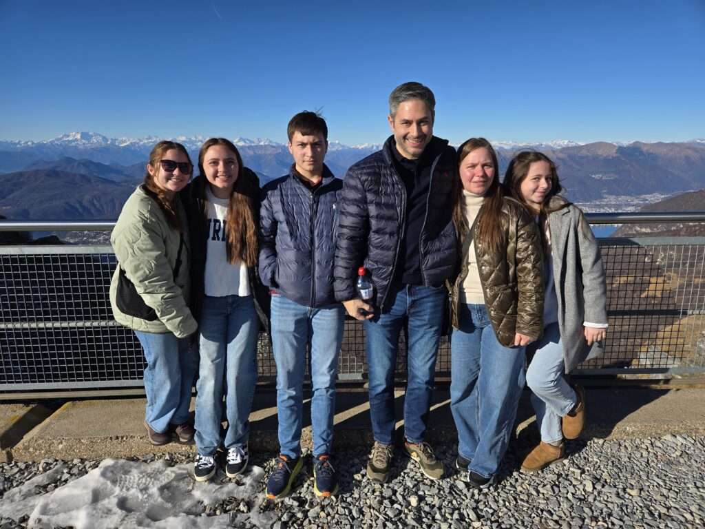 Six person family posing on mountain top